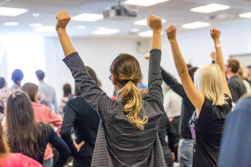 como motivar funcionários: colaboradores motivados com as mãos levantadas