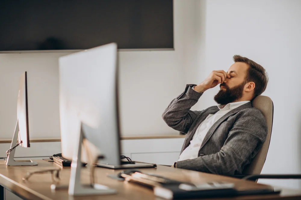 procrastinação no trabalho: homem com as mãos nos olhos