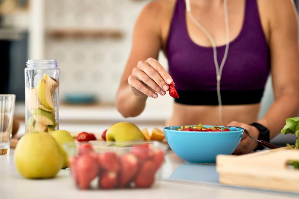 Reeducação alimentar: mulher organizando frutas diversas em um bowl