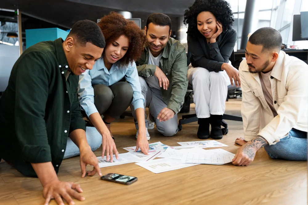 Trabalho em equipe: time de cinco colaboradores reunidos trabalhando em colaboração